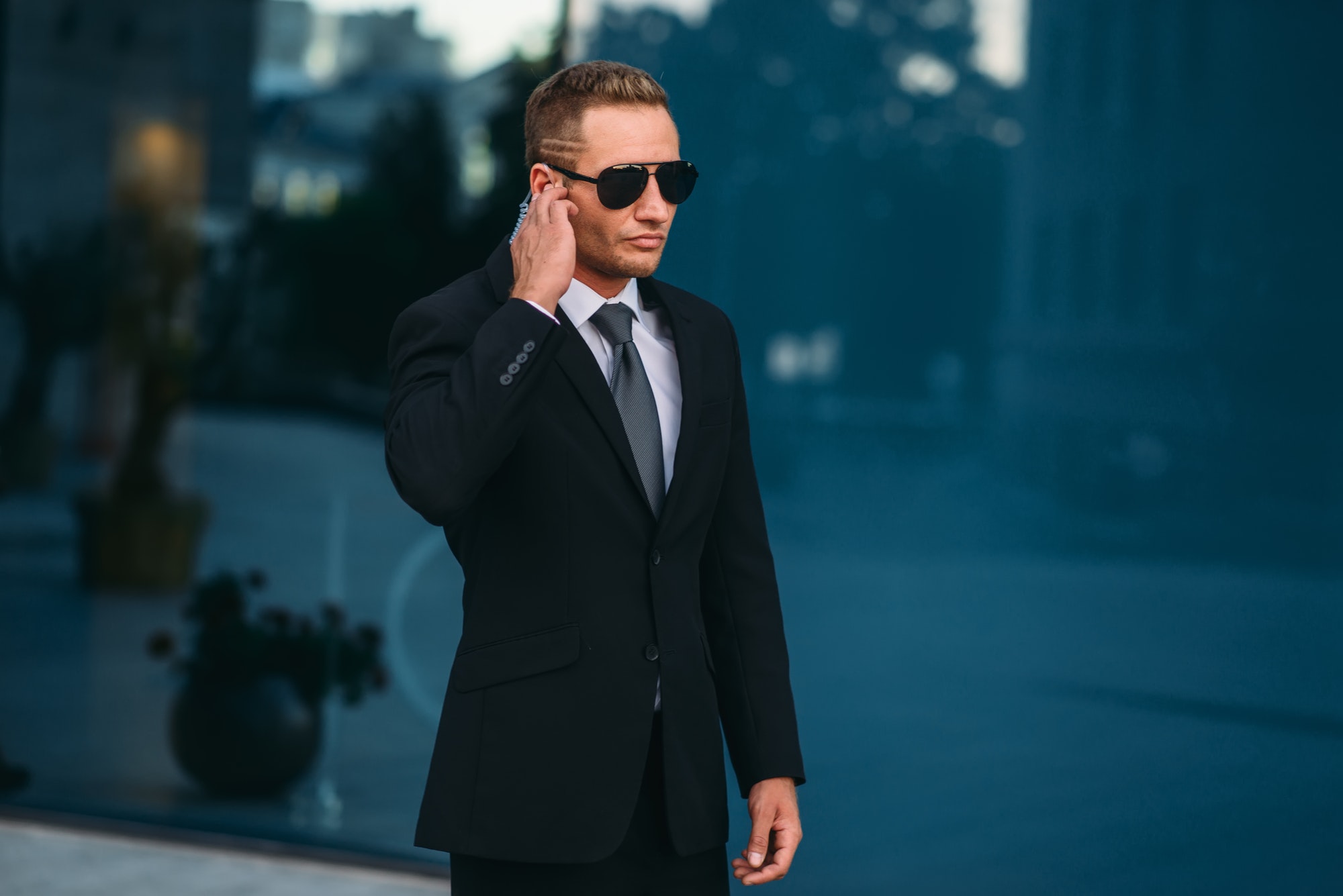 Bodyguard using a security earpiece outdoors
