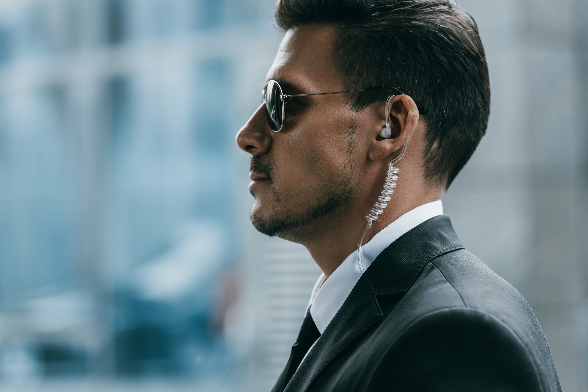 Profile of a security guard wearing sunglasses and a security earpiece