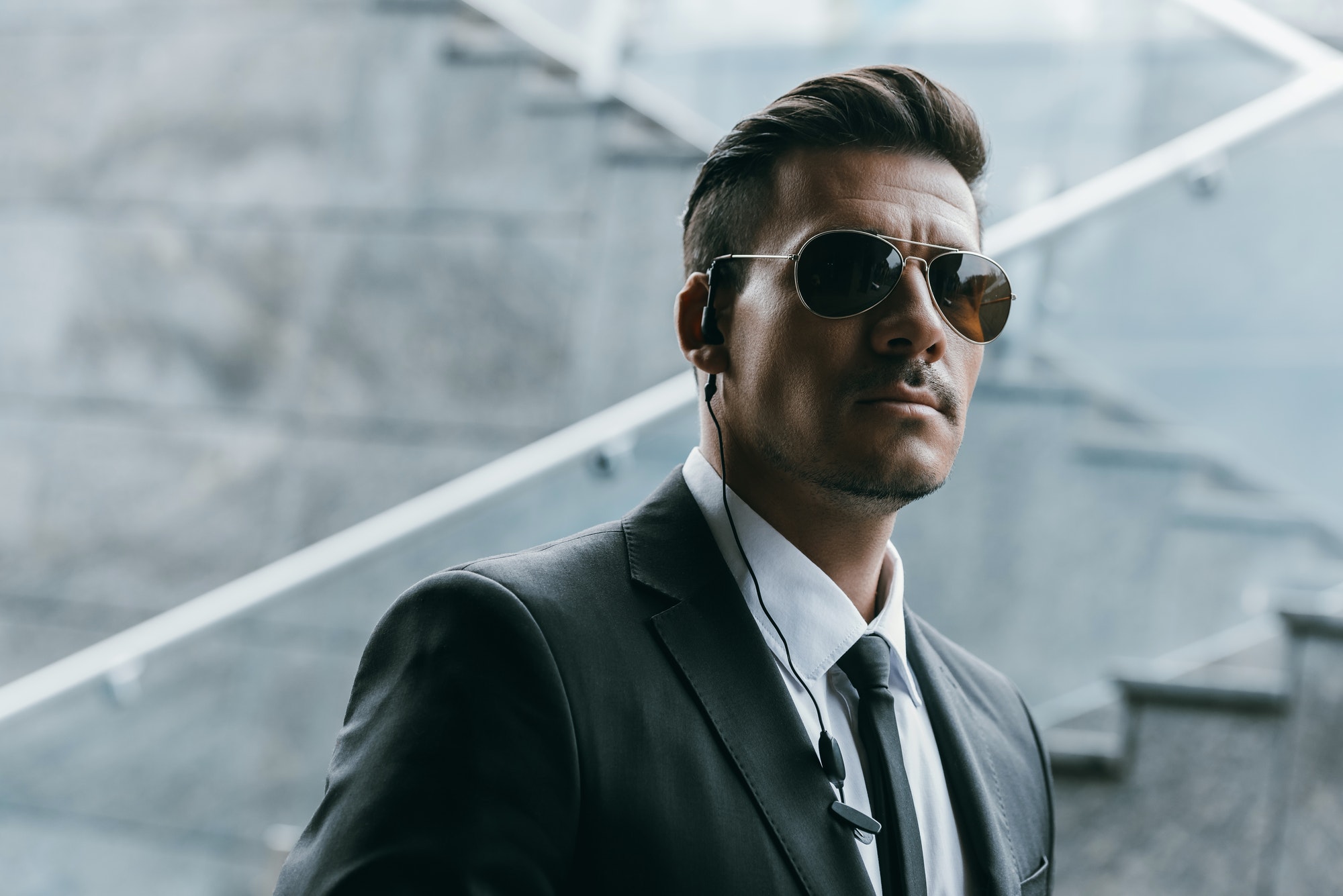 Security guard in sunglasses wearing a security earpiece