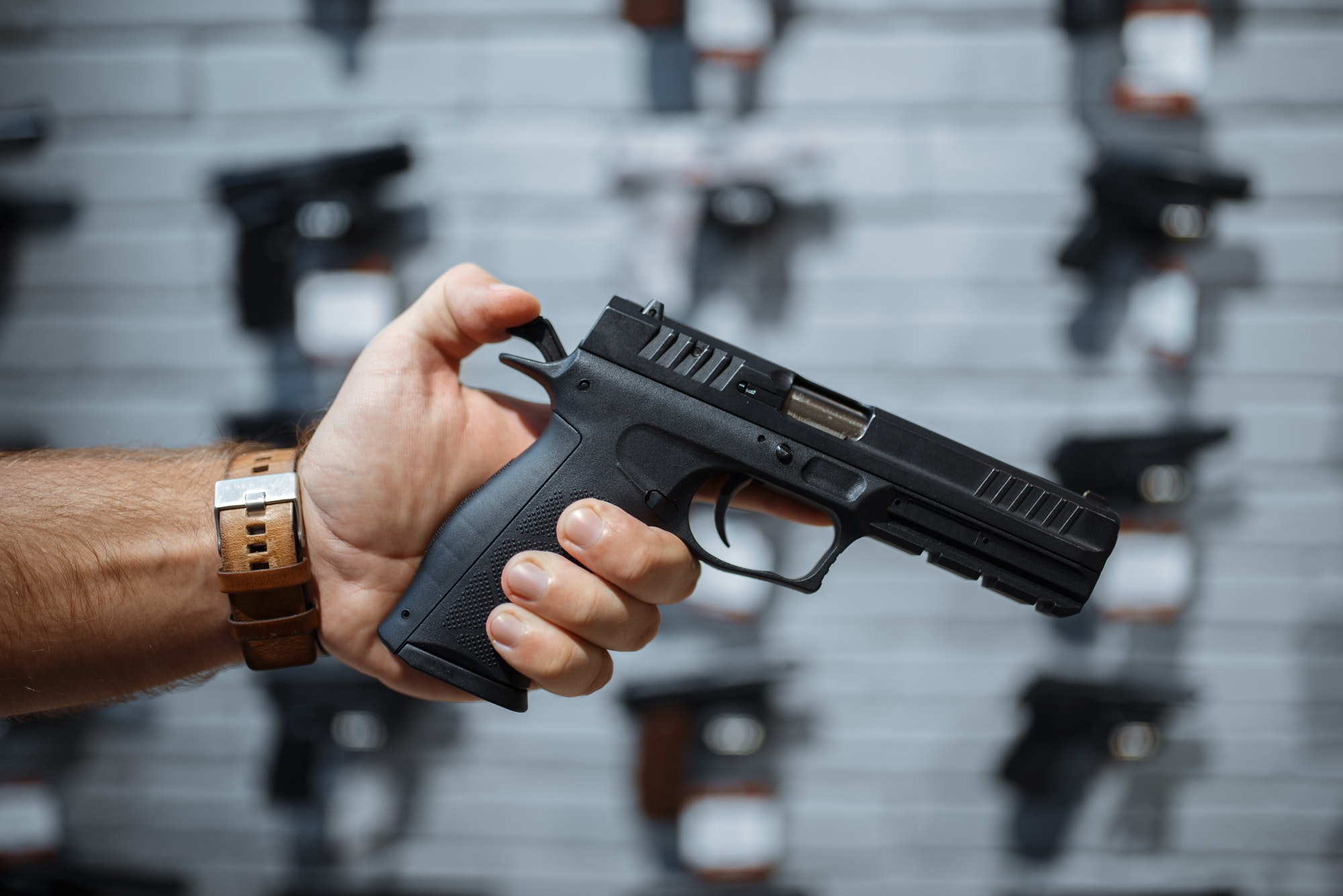 Man choosing new handgun in gun shop